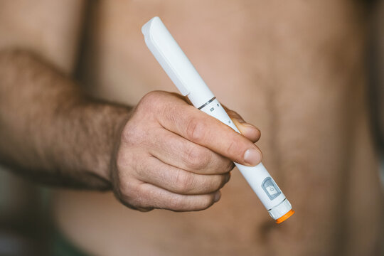 Man holding pen with GLP-1 medicine. Semaglutide, Ozempic, Tirzepatide or insulin drug against fat. Modern weight loss treatment, diabetes therapy and obesity management