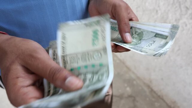 Man counting 500 rupees indian currency notes.