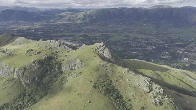 Drone flies forward and descends on south side of Sheba's Breast mountain on sunny afternoon in Ezulwini Valley, Eswatini