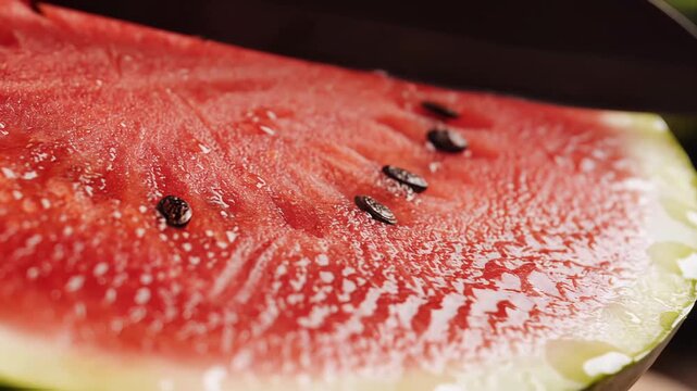 Close up macro shot of a juicy red watermelon slice with water droplets.