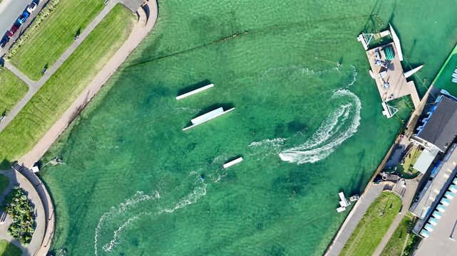 4K aerial drone footage of Hove Lagoon showcasing high-energy wakeboarding action. Sunny seafront watersports hub with cable riders, extreme sports vibes and dynamic coastal activity.