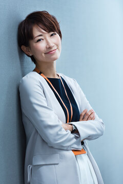 オフィスの壁に寄りかかる30代ビジネス女性
