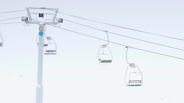 Ski lift operating in snowy mountains during winter storm in Las Lenas Mendoza Argentina.