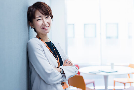 オフィスの壁に寄りかかる30代ビジネス女性