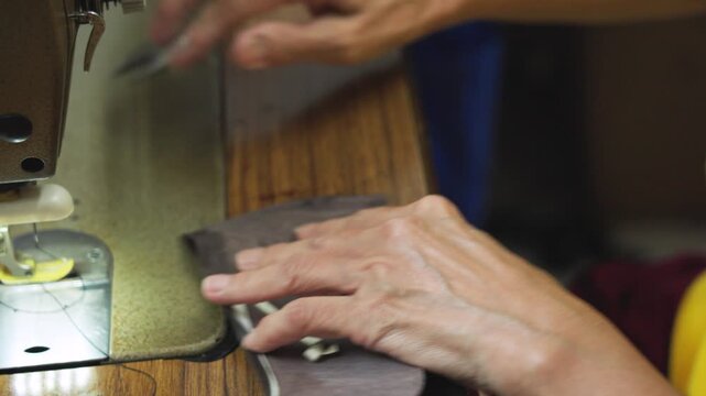 Close-up of removing a thread from a shoe vamp in Malaysia. Skilled hands carefully undo stitching, highlighting the repair process, precision work, and traditional cobbler craftsmanship. UHD.