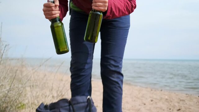 Hiker taking bottles from backpack at lakeside campsite, preparing supplies during outdoor adventure, camping activity, travel lifestyle, close-up action, nature vacation and trekking journey