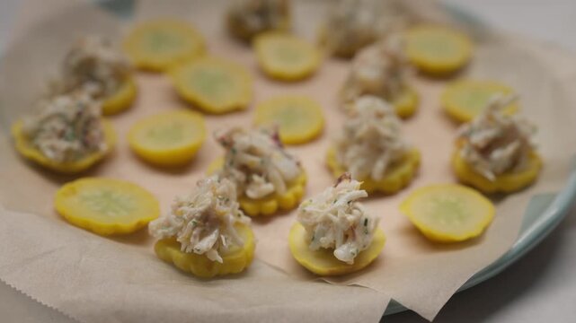 Preparing an hors d'oeuvre plate of snow crab and pattypan squash (slow motion 4K).