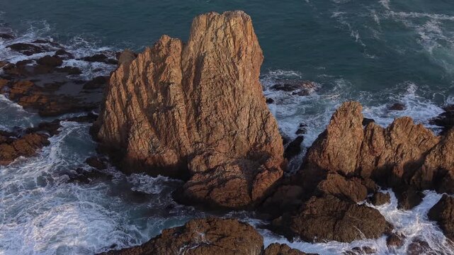 Majestic aerial view of the volcanic rock formations of Sirens Reef in Cabo de Gata Nijar Natural Park with waves breaking on the shore