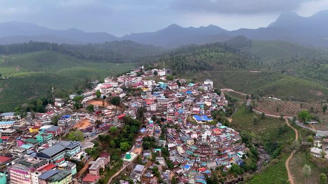 Drone shot capturing a vibrant townscape with a prominent church structure at the center, featuring colorful rooftops, busy streets, and a mix of residential and commercial buildings.