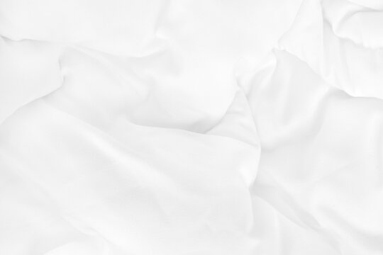 Close up top view of white bedding sheet and wrinkle messy blanket in bedroom after wake up in the morning.