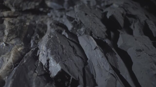 Gray rough textured shale rock surface breaking apart