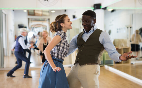 Woman with african man practising charleston dancing