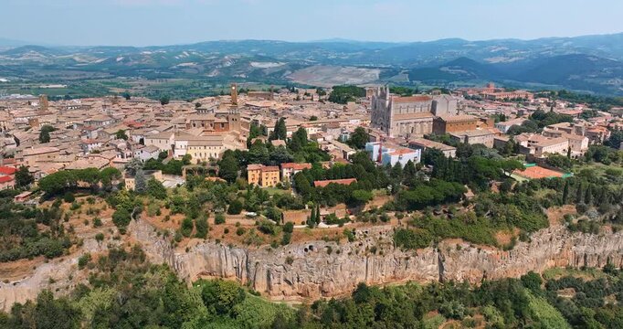 Orvieto Italy aerial view urban history. Ancient stone architecture cathedral hilltop town tuff rock. Summer vacation concept Italy tourism destination high angle drone shot exploration heritage.