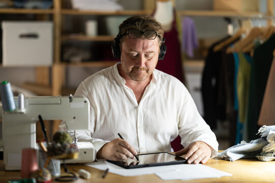 Male tailor create sketch of dress on tablet