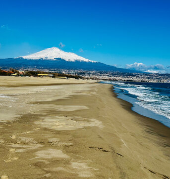 Vista del vulcano Etna innevato dalla spiaggia della playa di Catania