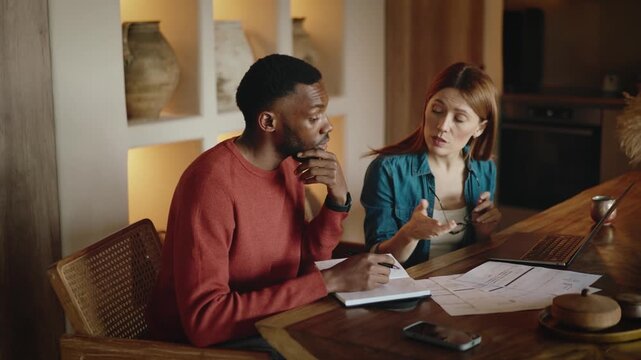 Interracial Couple Managing Finances at Home with Bills and Laptop During Financial Stress and Conflict