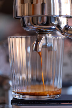 glass with coffee flowing from the portafilter