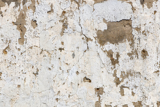 rotten white paint peeling at a plaster wall