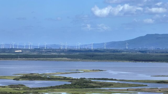 Aerial view of the Tramandai River wetlands with Borussia Hill and a distant wind farm on the horizon.