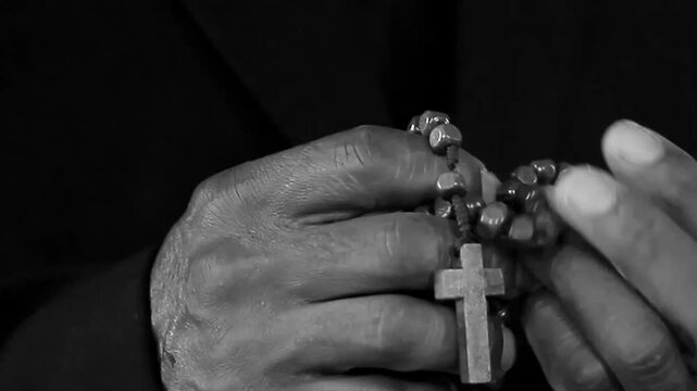 praying to God with hand's together with crucifix with people on black background stock video stock footage