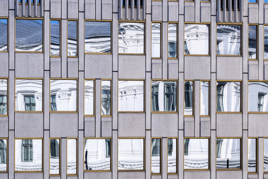 Modern urban building architecture facade with windows grid pattern and abstract symmetry creating a structured geometric background for design