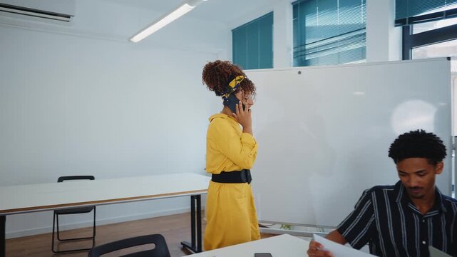 Multicultural business people brainstorming and talking about a new project during a briefing, analyzing data and charts on papers and laptops in a bright and modern conference room