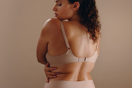 Curvy woman wearing nude bra and lingerie showing confidence