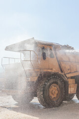 A large mining dump truck is being washed at an open-pit mine. © Tanes