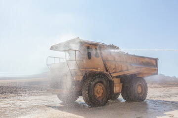 A large mining dump truck is being washed at an open-pit mine. © Tanes