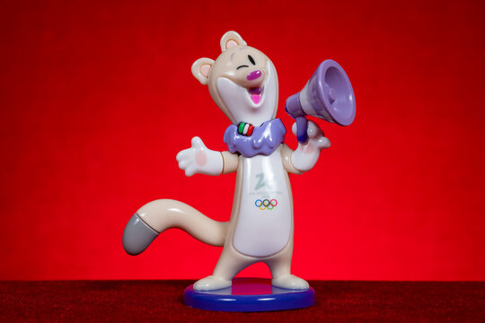 ZHONGSHAN China-April 2 2026: the stoat mascot Tina of the Milano Cortina 2026 Winter Olympics on red background at horizontal composition.