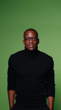 Confident man in black turtleneck and glasses on green screen background. Perfect for marketing, business, and corporate videos.