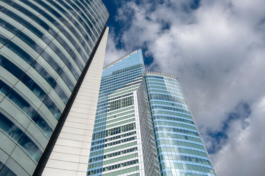 Clouds above La Defense paris as lowangle modern glass towers define skyline and urban architecture for finance and business headquarters