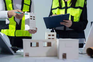 Fototapeta premium Engineer teams hand working and laptop with on on architectural project at construction site at desk in office.
