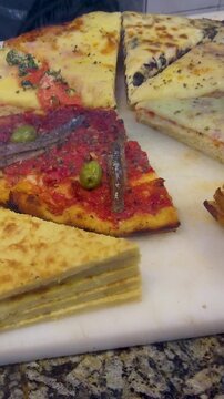 Vertical Close Up of Traditional Argentine Pizza with Anchovies and Faina in Buenos Aires