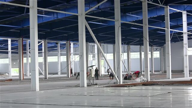 Industrial factory construction process. A group of construction workers. Industrial Construction. Construction of a large modern factory in its final stages.