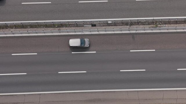 Drone aerial view of European transport corridor on Italian highway. Continuous traffic flow of cars and trucks represents cross-border mobility and logistics connectivity.