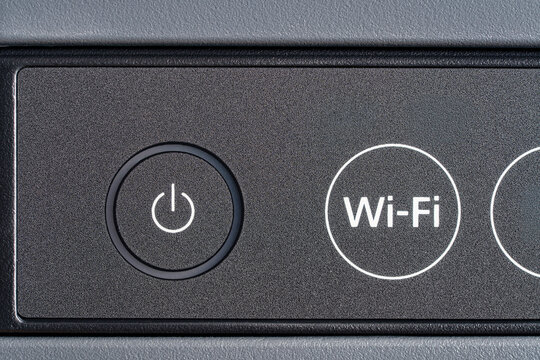 Closeup of power and Wi-Fi buttons on electronic device panel. Macro shot of control panel. Concept of wireless technology modern office equipment and smart home devices