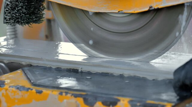  mechanical cutter designed for slicing through hard materials.man cuts deck tiles. Mechanical tile cutting machine in operation.Close-up of a saw blade cutting deck tiles. 4k footage