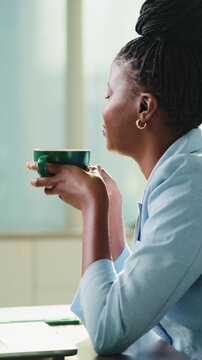 Black woman, coffee and thinking in office for business, finance and stress relief on break. Female accountant, tea and reflection in firm for productivity, planning day and daydreaming in company