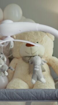 Close-up of a baby crib mobile featuring plush toys, including a teddy bear and sheep, designed to entertain infants