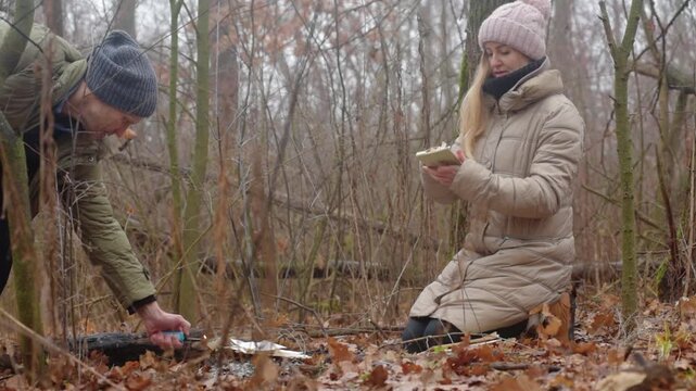 Man and woman going to burn evidence of crime in forest Symbolic farewell and emotional release. Destruction of sensitive information in isolation. Solitary reflection and transformative ritual.