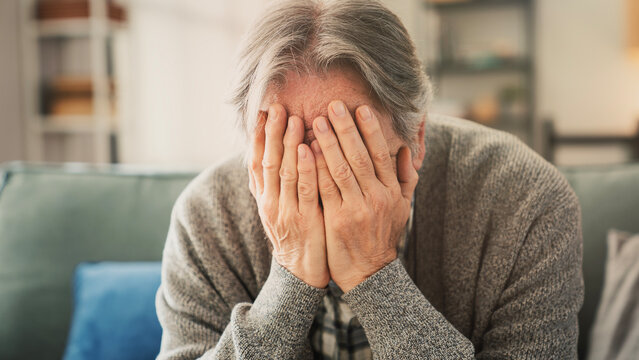 Old man covering face with hands