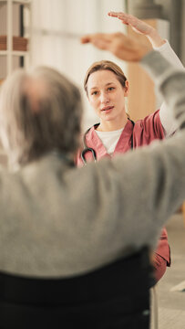 Physiotherapist assisting a senior man with exercise