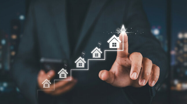 Businessman pointing at floating house icons, symbolizing real estate growth and investment opportunities