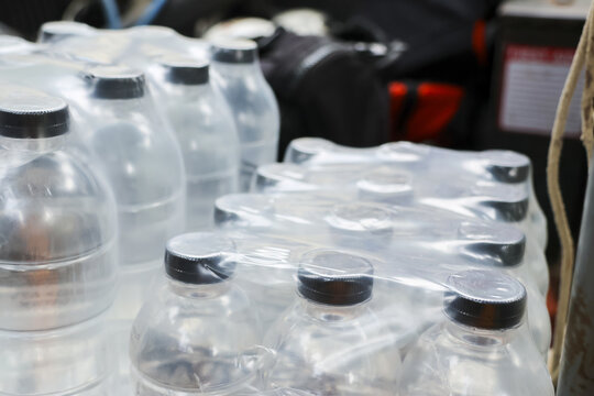 Clear plastic water bottle package wrapped for safe hydration. Bulk pack provides reliable storage for emergency drink supply, giving feeling of secure preparation and essential daily readiness