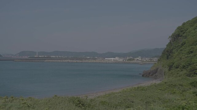 穏やかな海と緑豊かな山々が織りなす日本の海岸線/Japan's coastline, a tapestry woven from calm seas and lush green mountains.