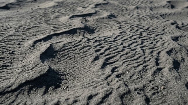 Close-up of textured sand surface with intricate patterns and shadows.