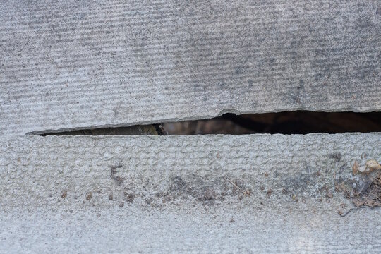 gray texture of slate dirty panel with crack and hole on day street