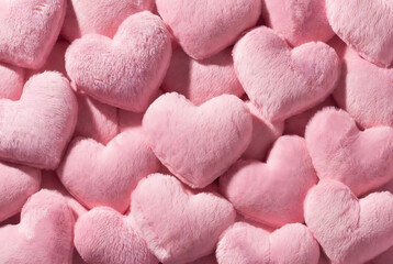 Obraz premium Subject: Pink heart-shaped plush toys. Action: A pile of hearts is densely arranged. Setting: An indoor setting, possibly a shop display.