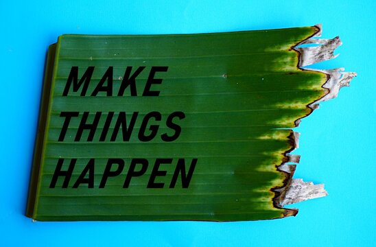 The words make things happen on torn green banana leaves, self-development concept, motivation to change life, taking action to make the desire a reality